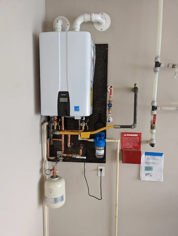 Professional plumber installing copper piping in a Wolfeboro home